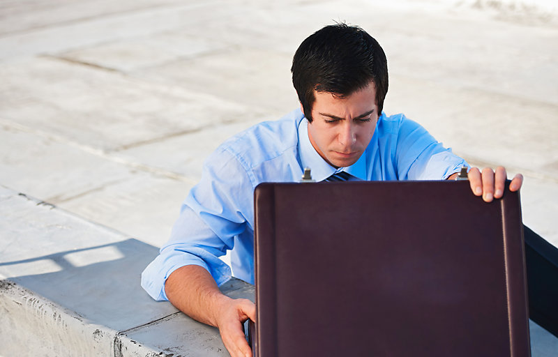 Man looking inside a briefcase.