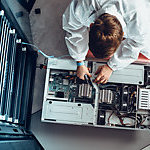 An IT engineer servicing parts of a computer.