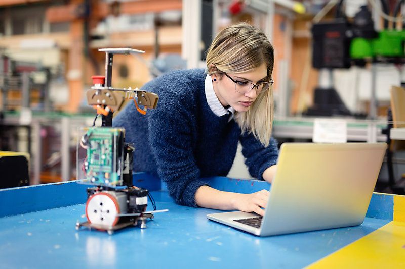 A young woman engineer working on a robotics project.