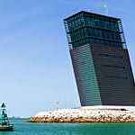 Sea port entrance framed to the right by the base of a modern-looking control tower.