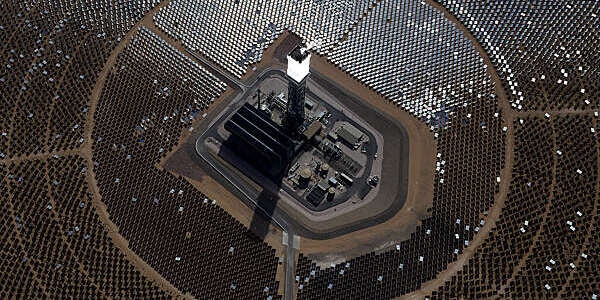 Aerial view of the Ivanpah solar electric generating system with its central tower, surrounded by hundreds of solar panels.